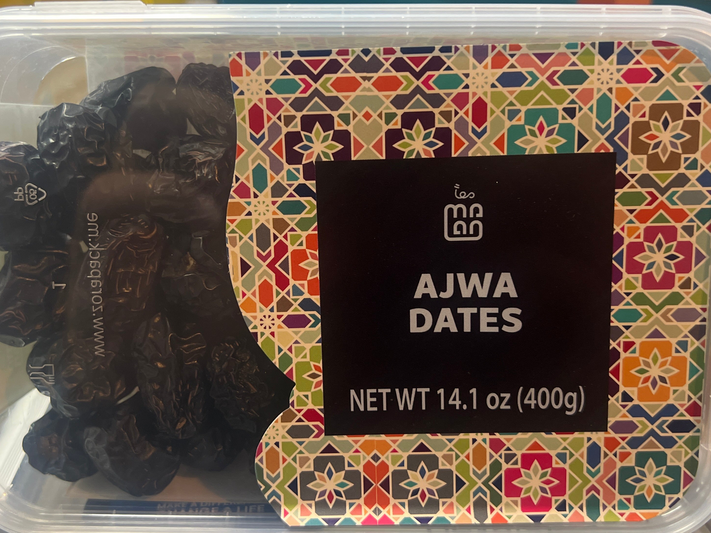 Container of Ajwa dates with decorative label