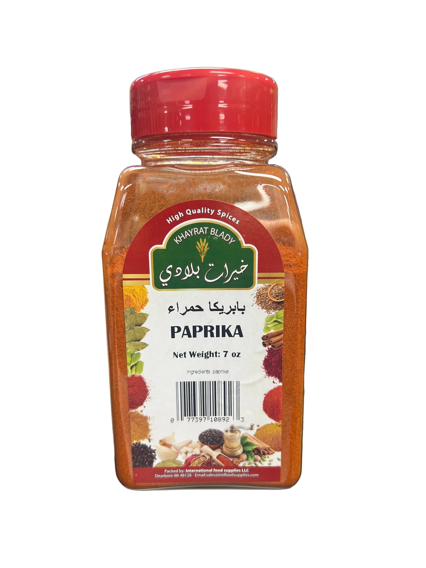 Hand holding a jar of paprika with a blurred grocery store background