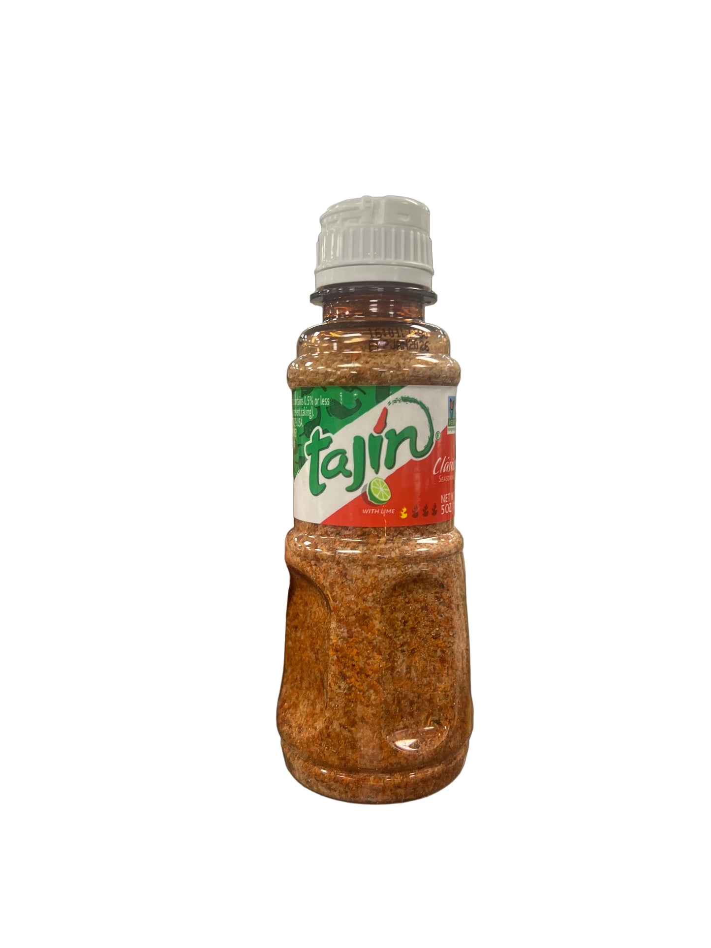 Hand holding a bottle of Tajin seasoning in a grocery store aisle.